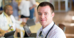 A smiling resident with a stethoscope in the hospital
